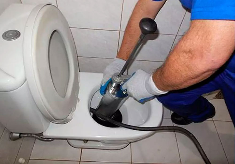 desentupidora: homem desentupindo vaso sanitário